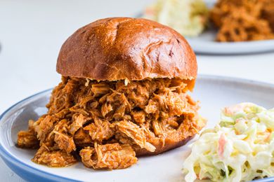 Pulled pork sandwich on a plate with coleslaw.