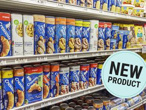 Shelves stocked with various brands and flavors of refrigerated dough products including crescent rolls and biscuits