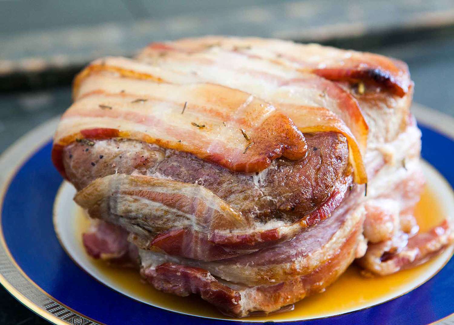 pork roast wrapped in bacon on a plate