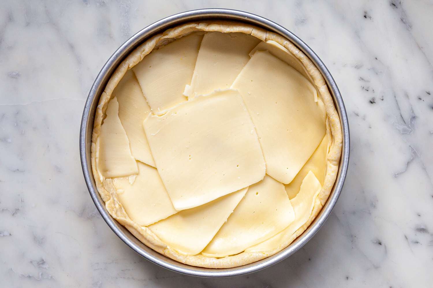 Cheese added to the bottom of the dough to make Chicago-Style Deep Dish Pizza.
