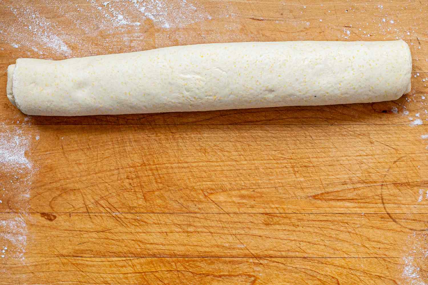 Dough rolled into a log to make Homemade Chicago-Style Deep Dish Pizza.