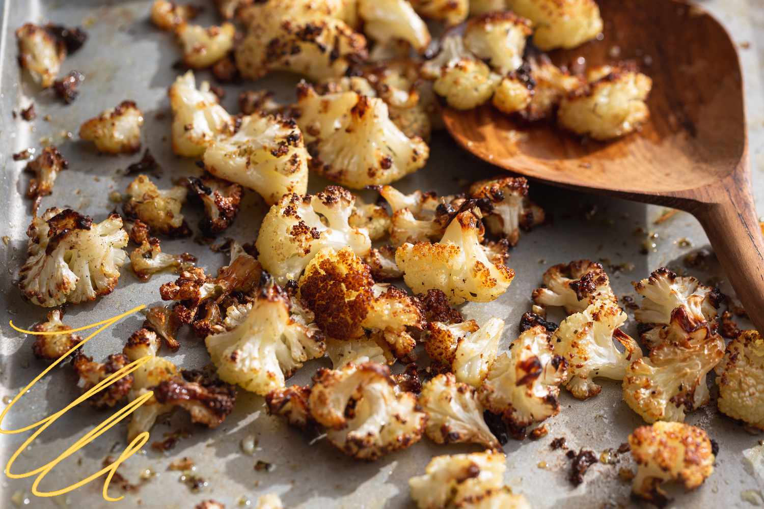Photo of roasted cauliflower on a sheet pan with yellow-lined illustrations on the corner