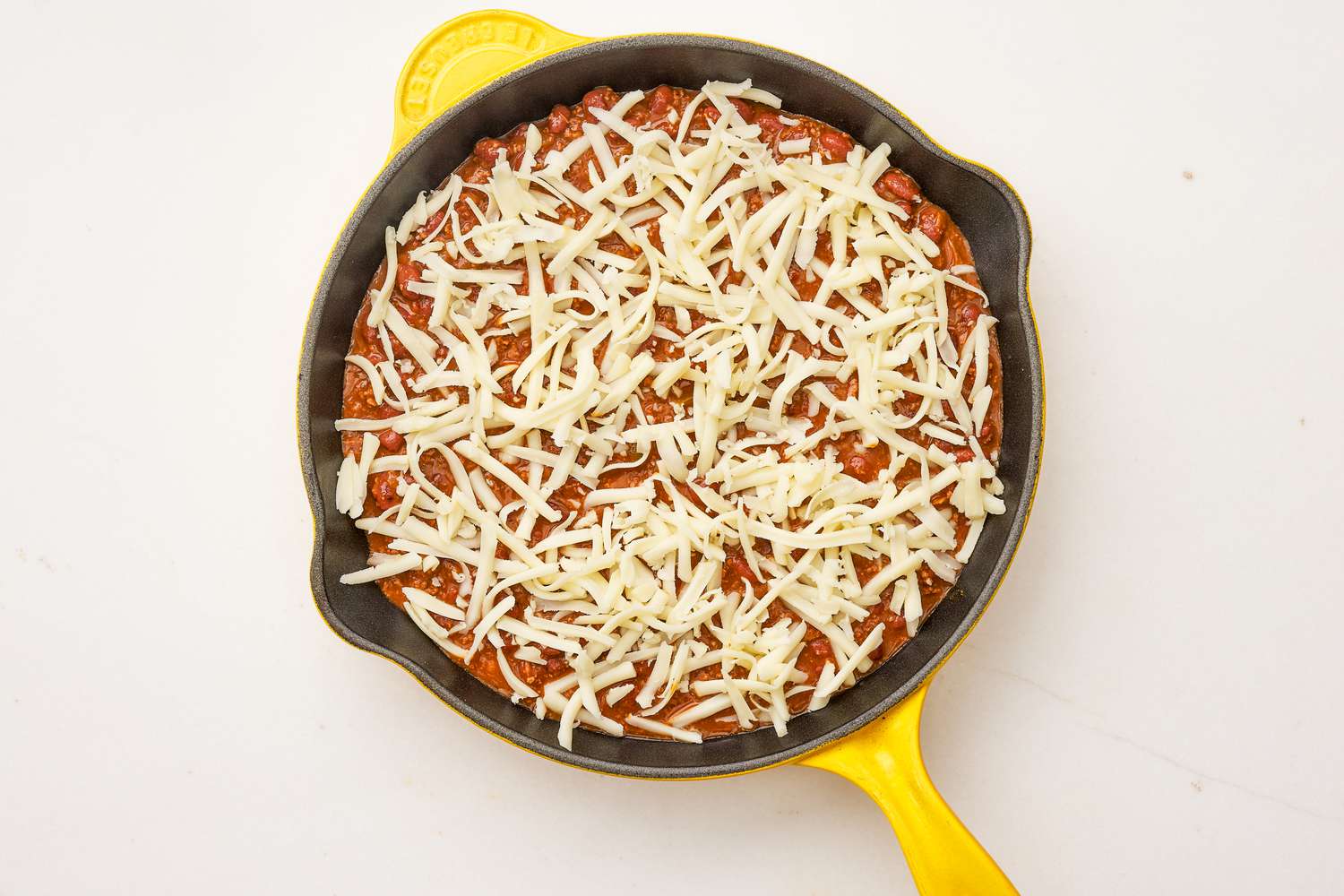 Frito pie dip topped with shredded mozzarella