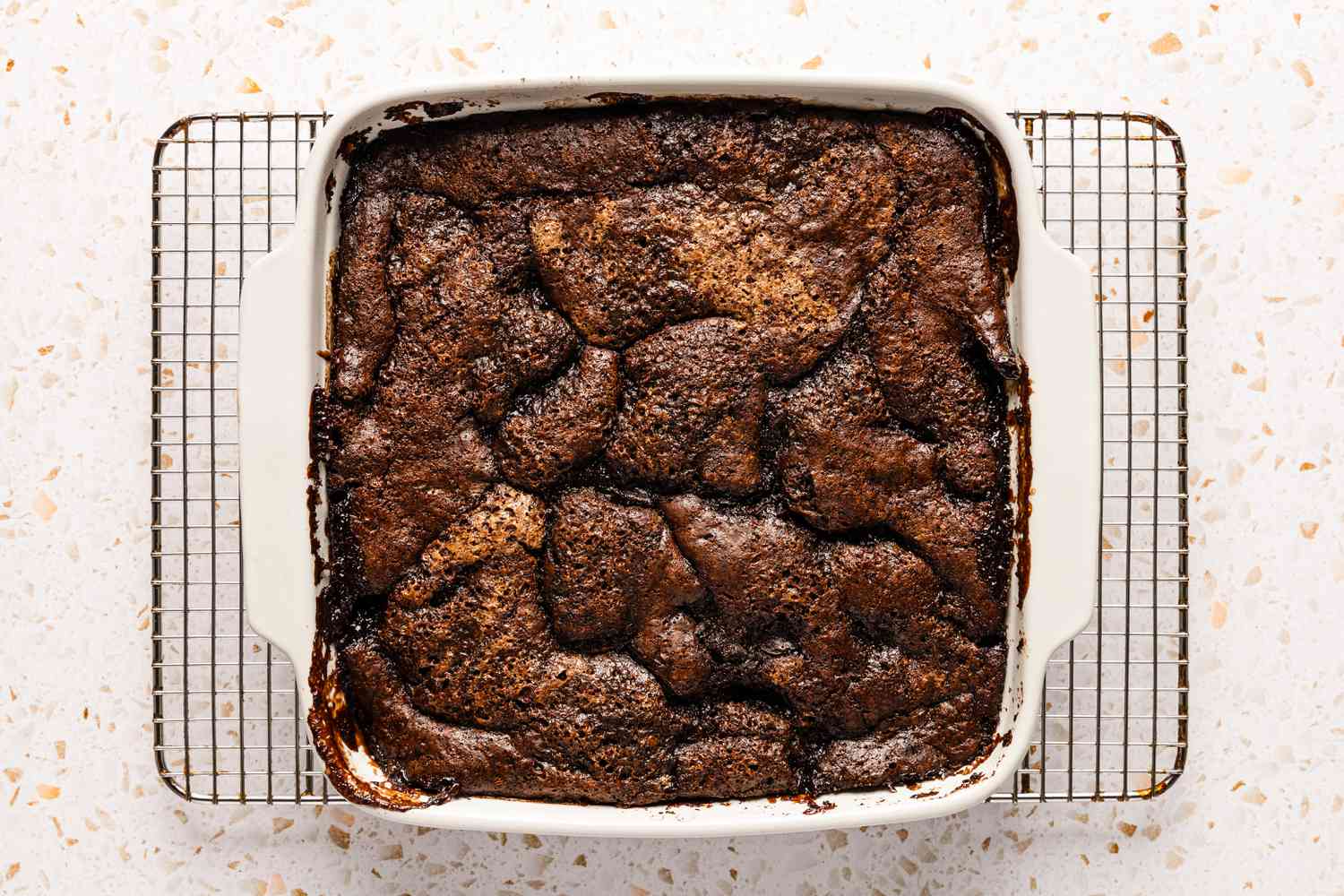 The chocolate cobbler recipe baked and cooling in the baking dish on a baking rack