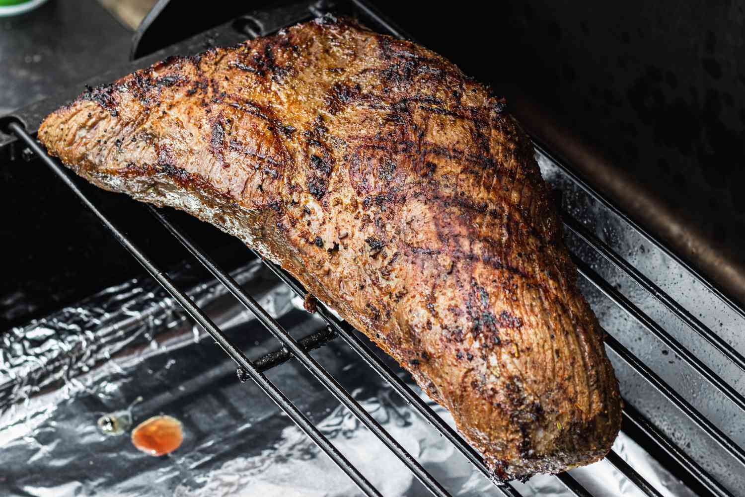 A Santa Maria tri tip cooking on the grill.