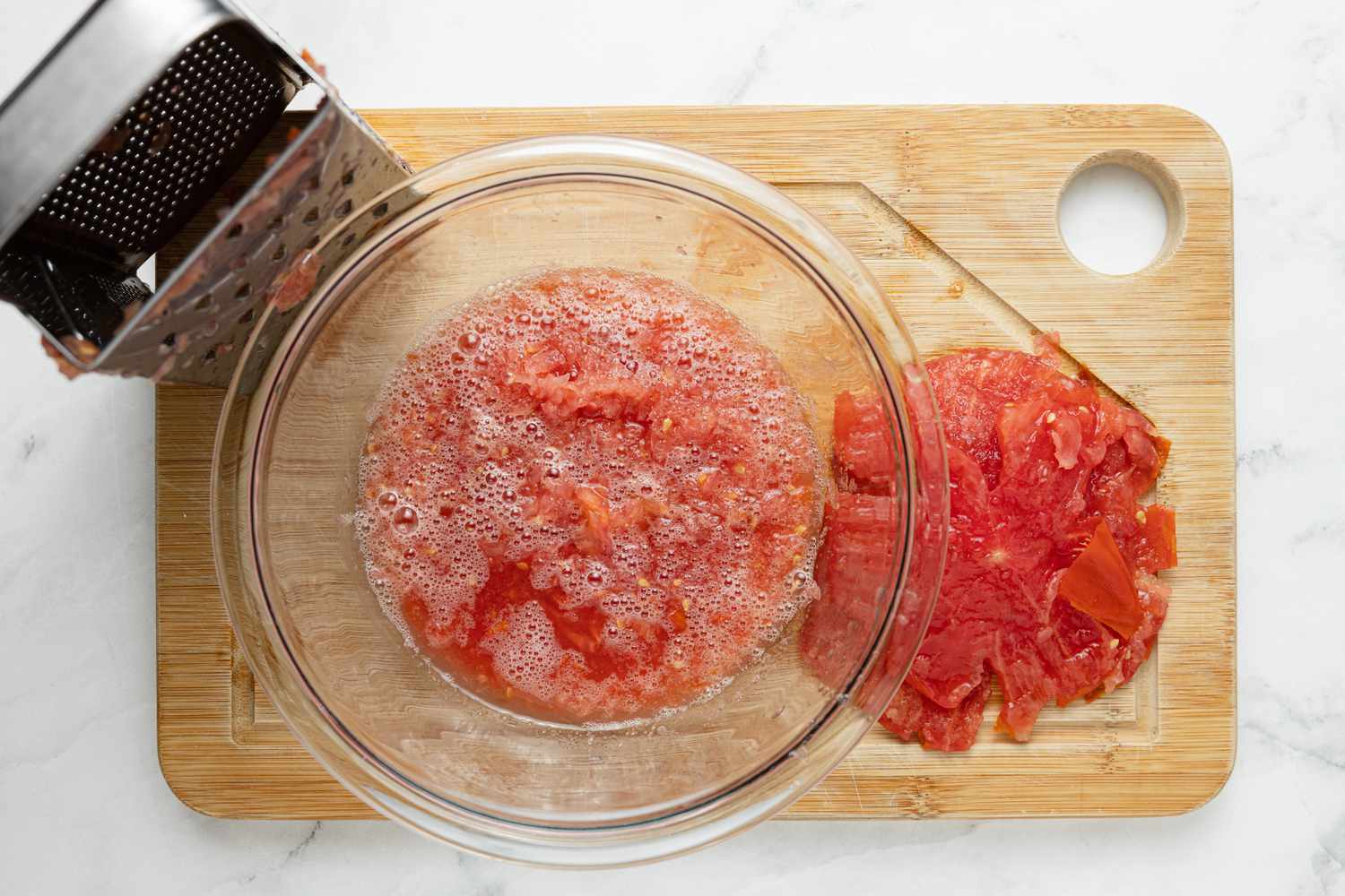 Grated Tomatoes in a Bowl with Skin on a Cutting Board for Menemen Recipe