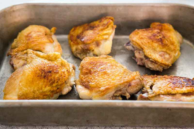 browned chicken thighs in a pan