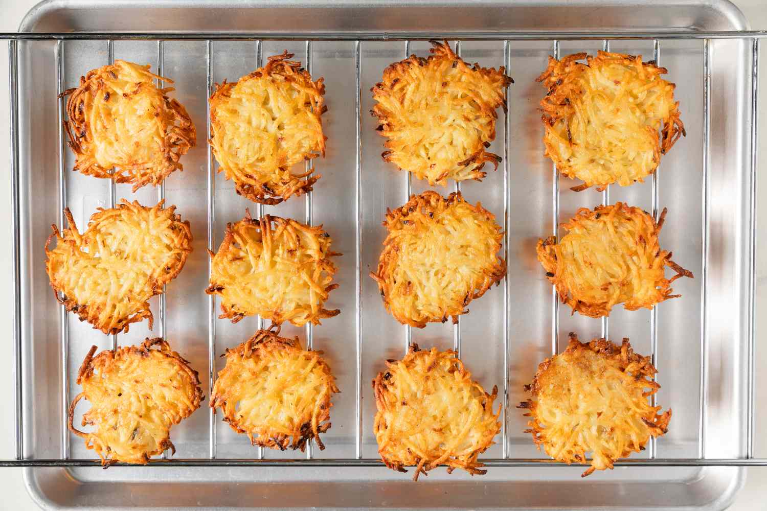 Latkes placed on a wire rack over a baking sheet