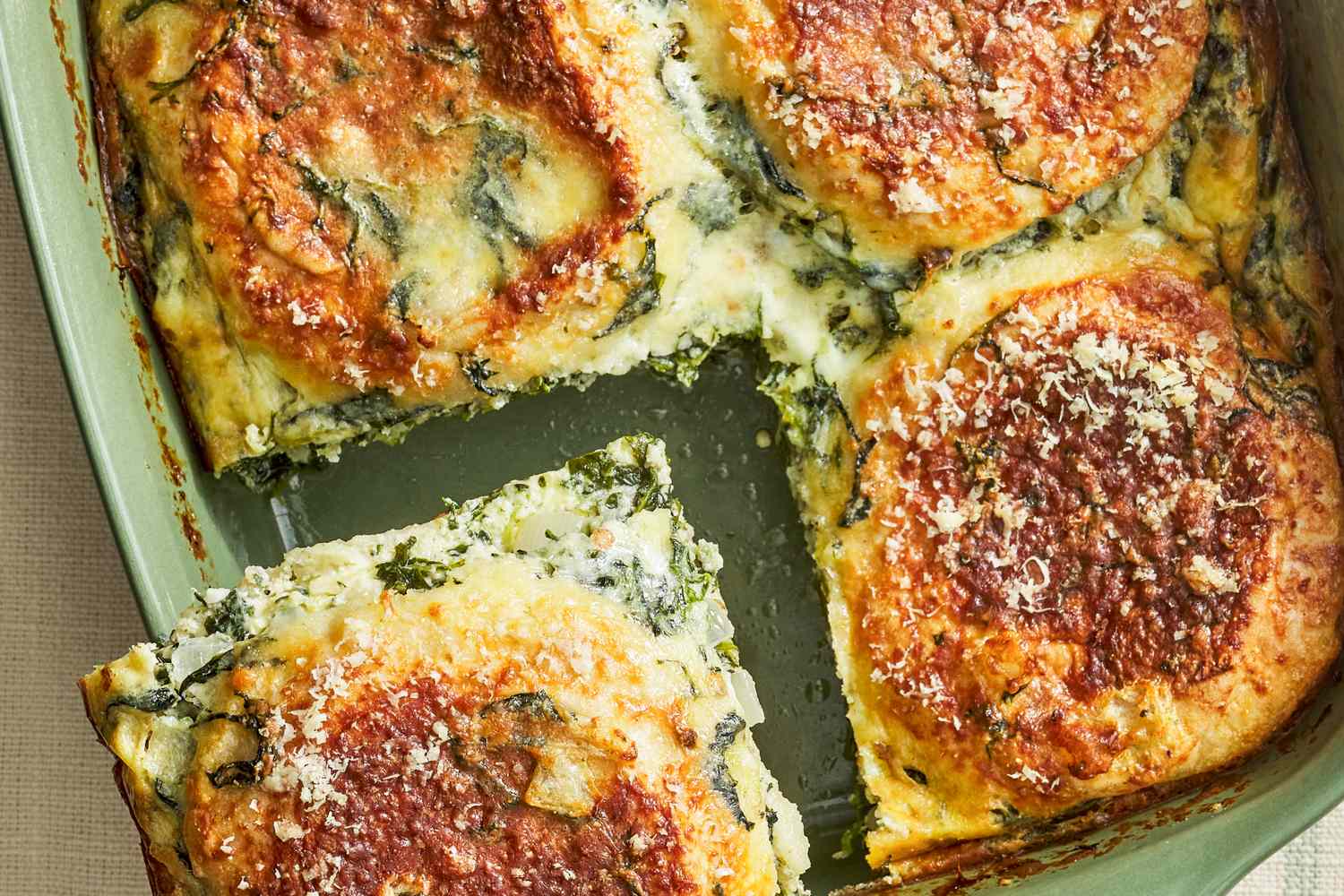 Breakfast casserole with melted cheese and baked layers a portion cut out