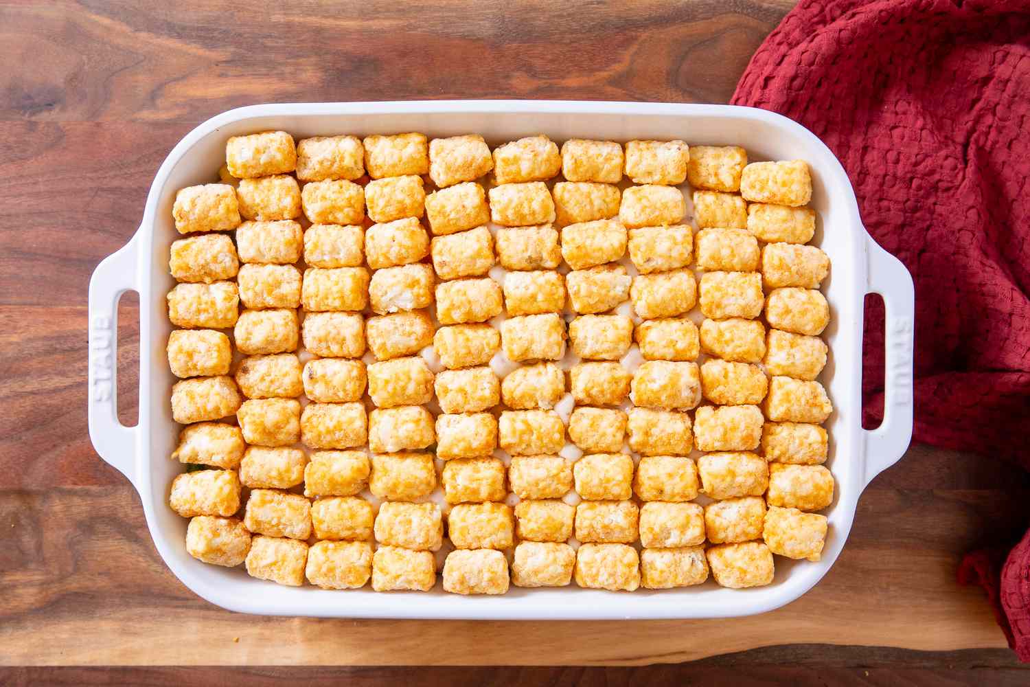 baking dish with hotdish layers topped with carefully placed tater tots for Classic Tater Tot Hotdish