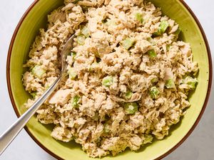Tuna salad with celery in a bowl displayed with a spoon