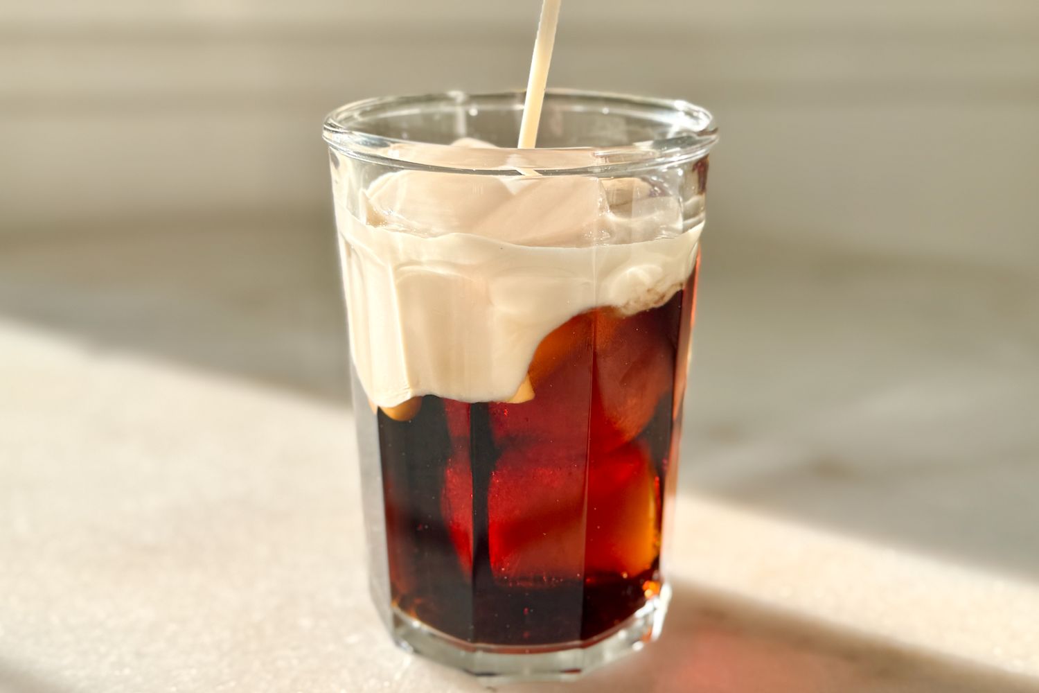 Glass of soda with whipped topping and a straw