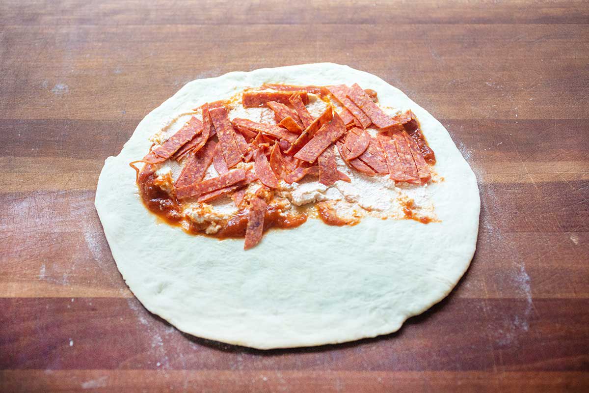 Pepperoni Calzone topped with sauce and pepperoni