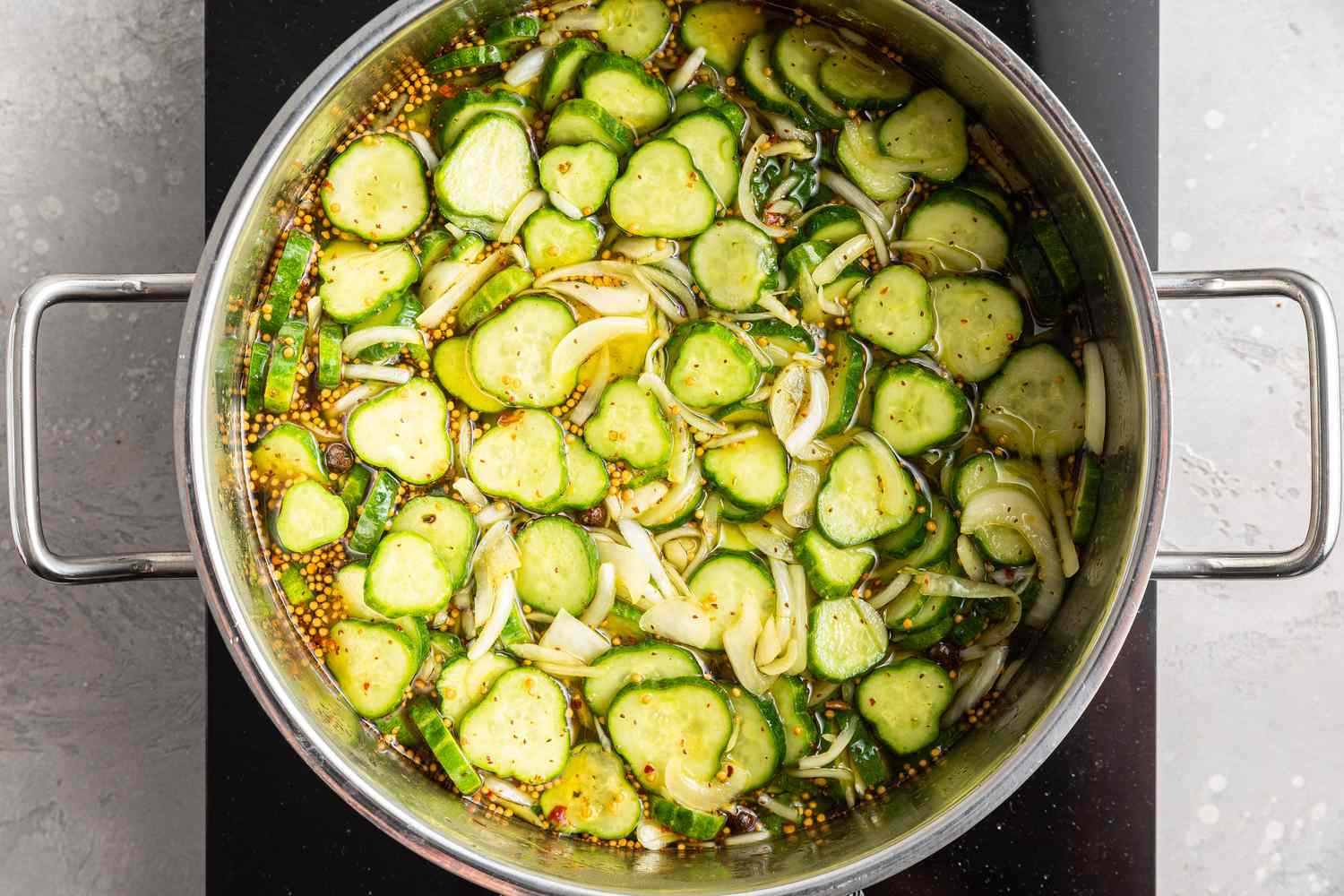 Cucumbers, onions, and other pickling Ingredients in a Pot 