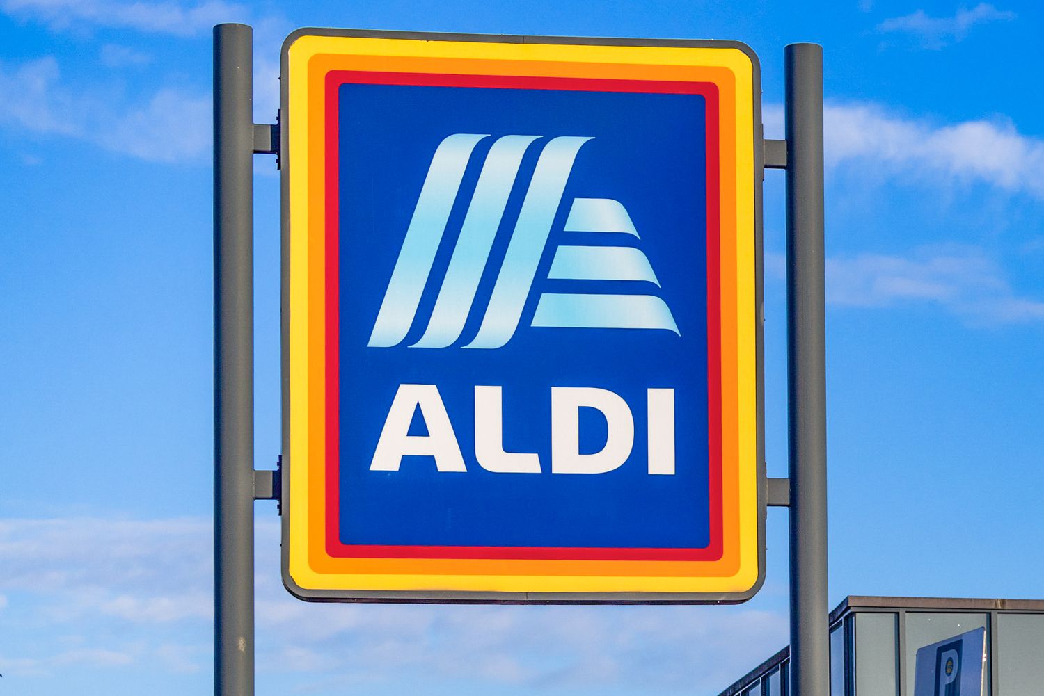 Outside view of a large ALDI sign with a blue sky in the background