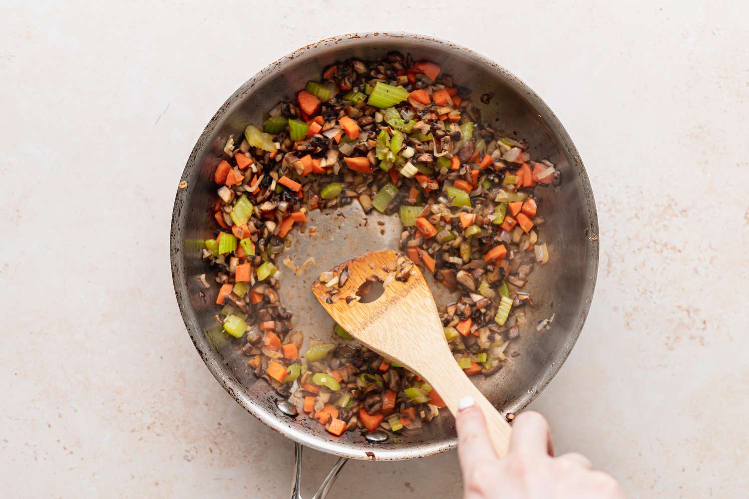 Stirring diced vegetables in a skillet to make stuffed squash.