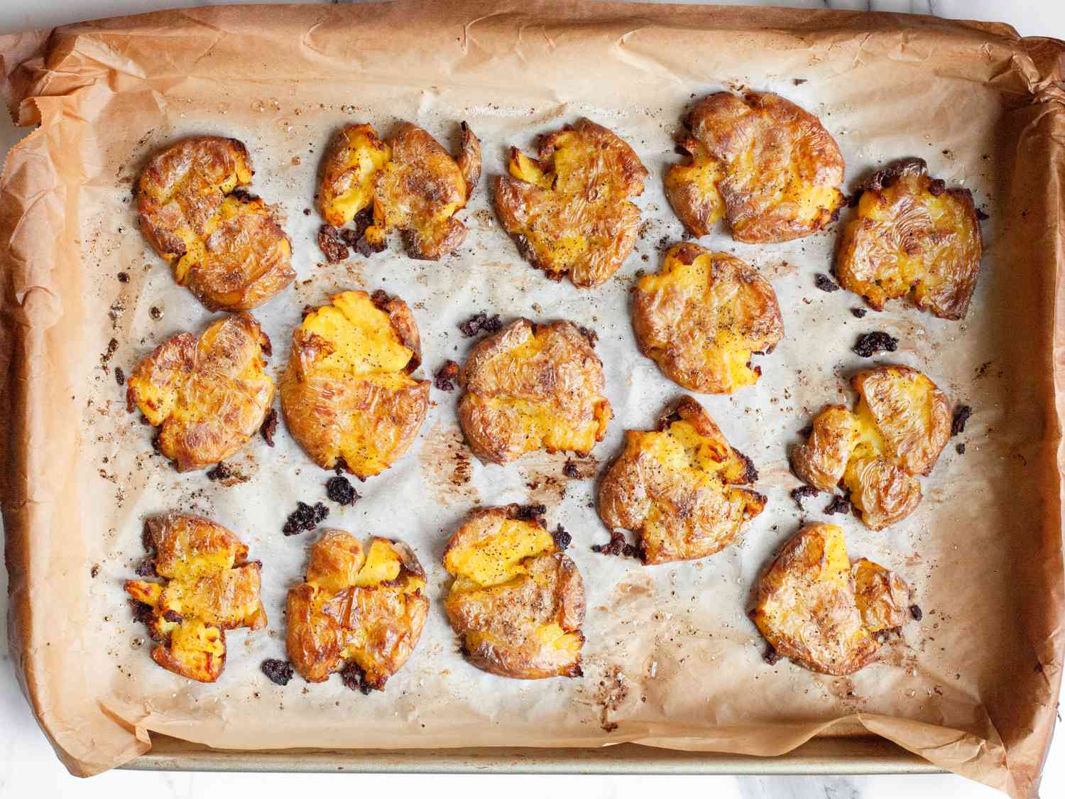 Smashed baked potatoes on a baking tray