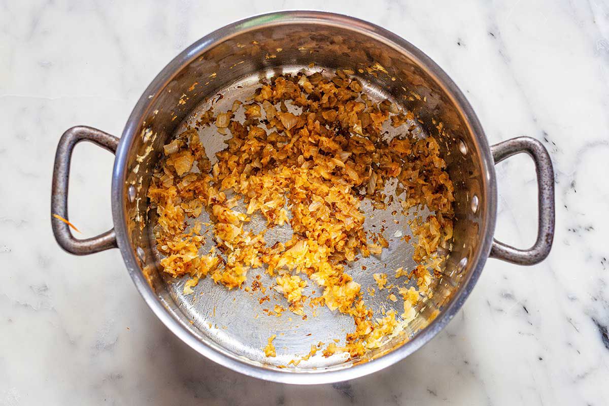 Caramelized onions and tomato paste in the bottom of a soup pot.