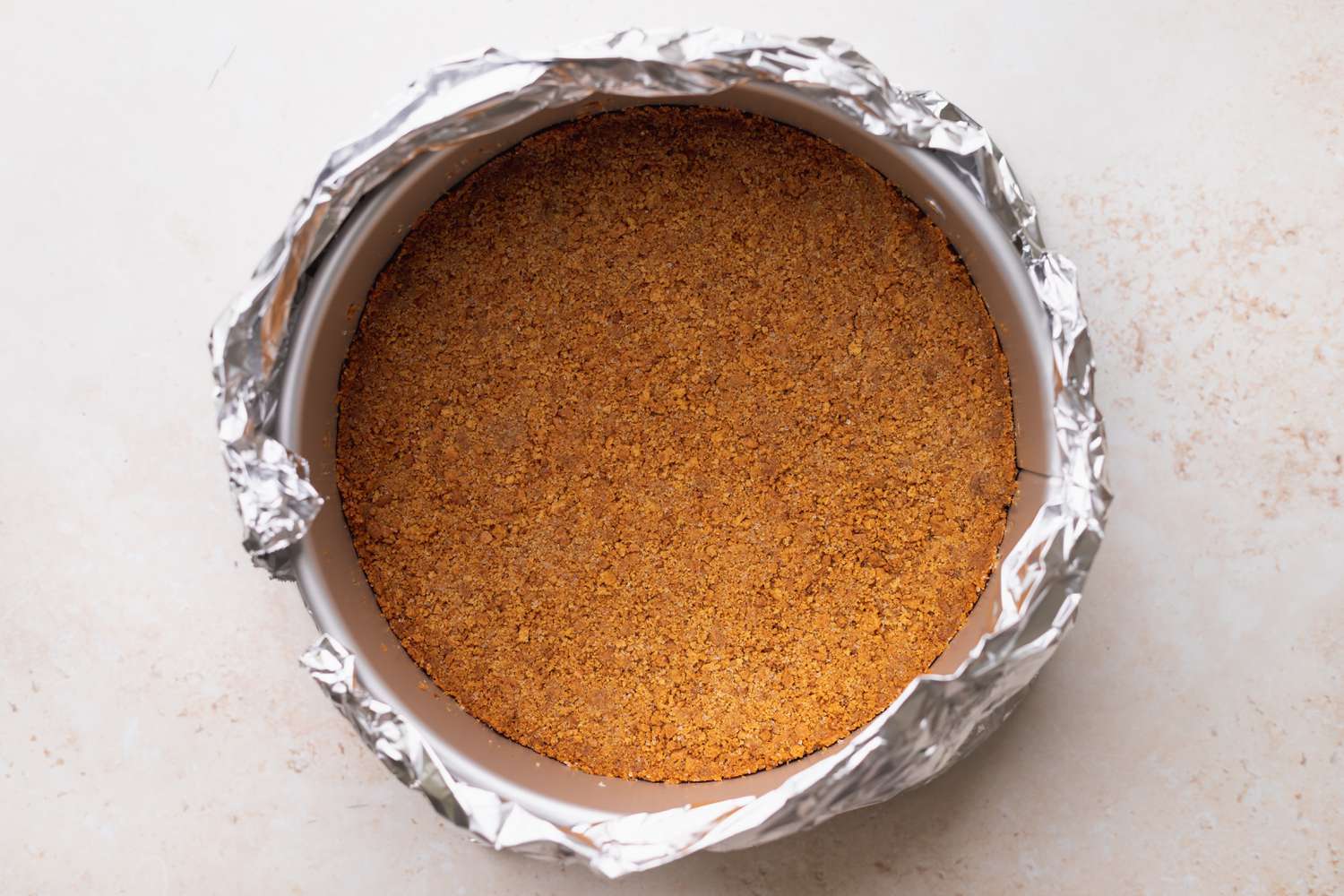 Springform pan wrapped with foil.