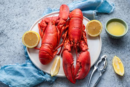 Plate of Lobster with Lemon Halves and a Bowl of Butter Sauce