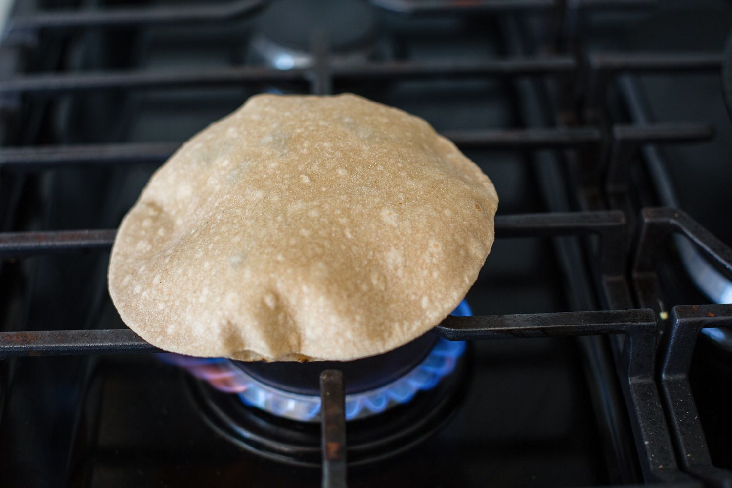 Showing how to make roti on the stovetop.