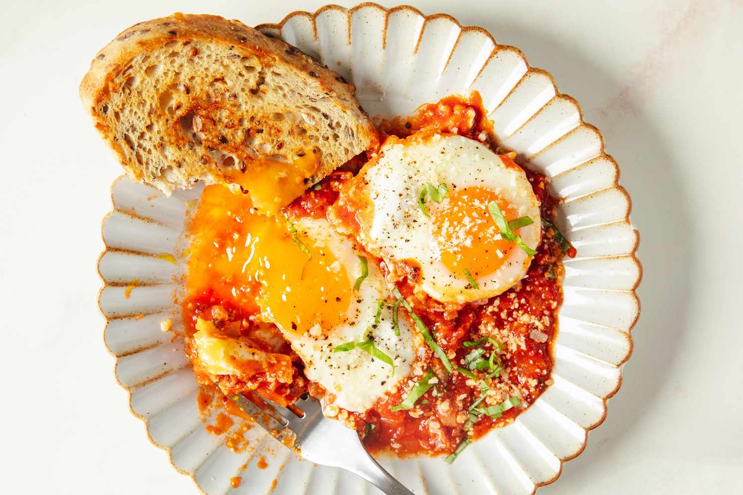 A plate of eggs in purgatory served with a slice of bread