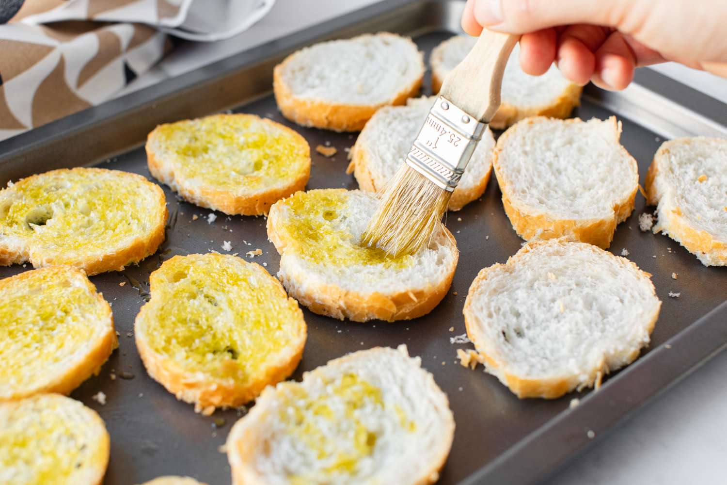 Bread Slices Brushed with Garlic Olive Oil on a Sheet Pan for Traditional Caesar Salad 