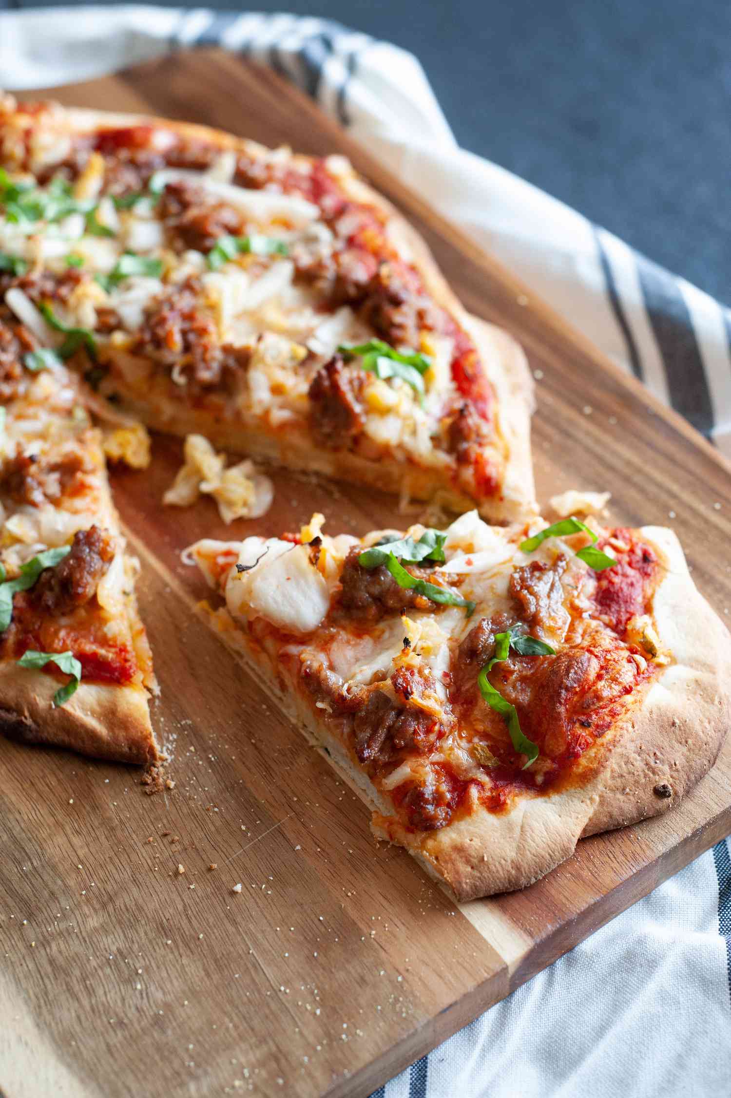 Kimchi sausage pizza with one slice removed