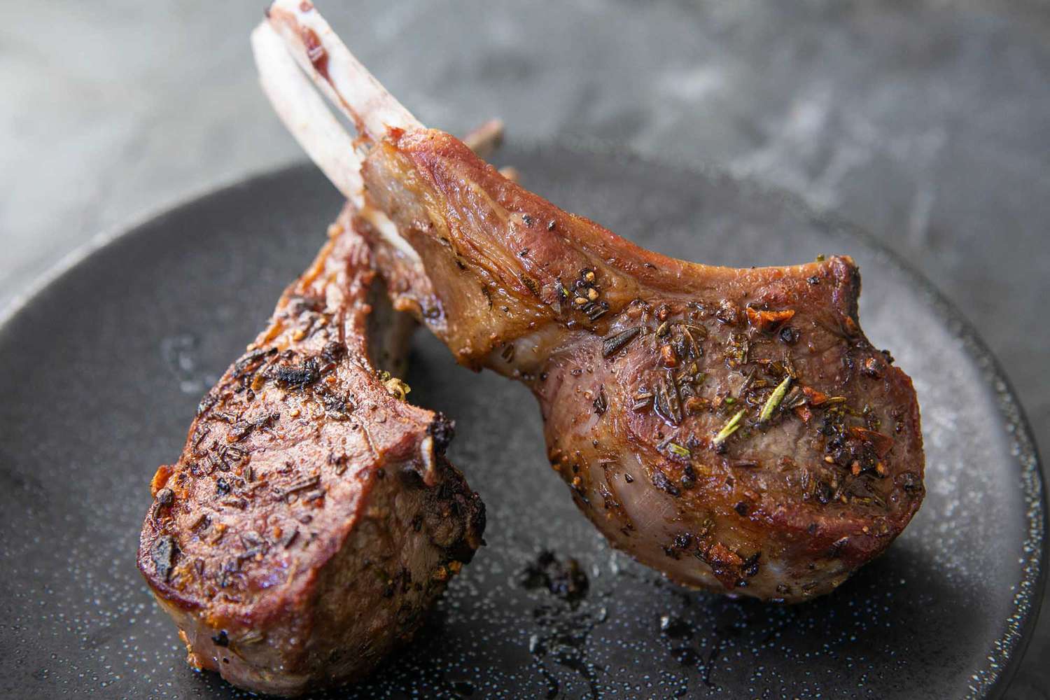 Two lamb chops with rosemary, served on a plate