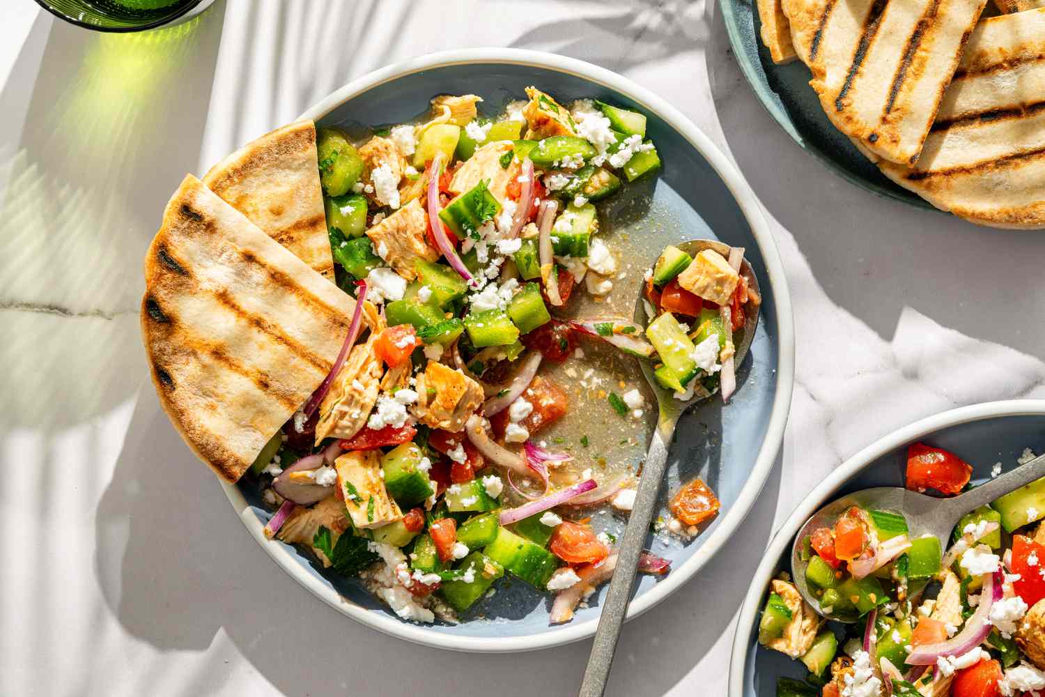 plate of Greek Grilled Chicken Salad with grilled pita pieces on the side