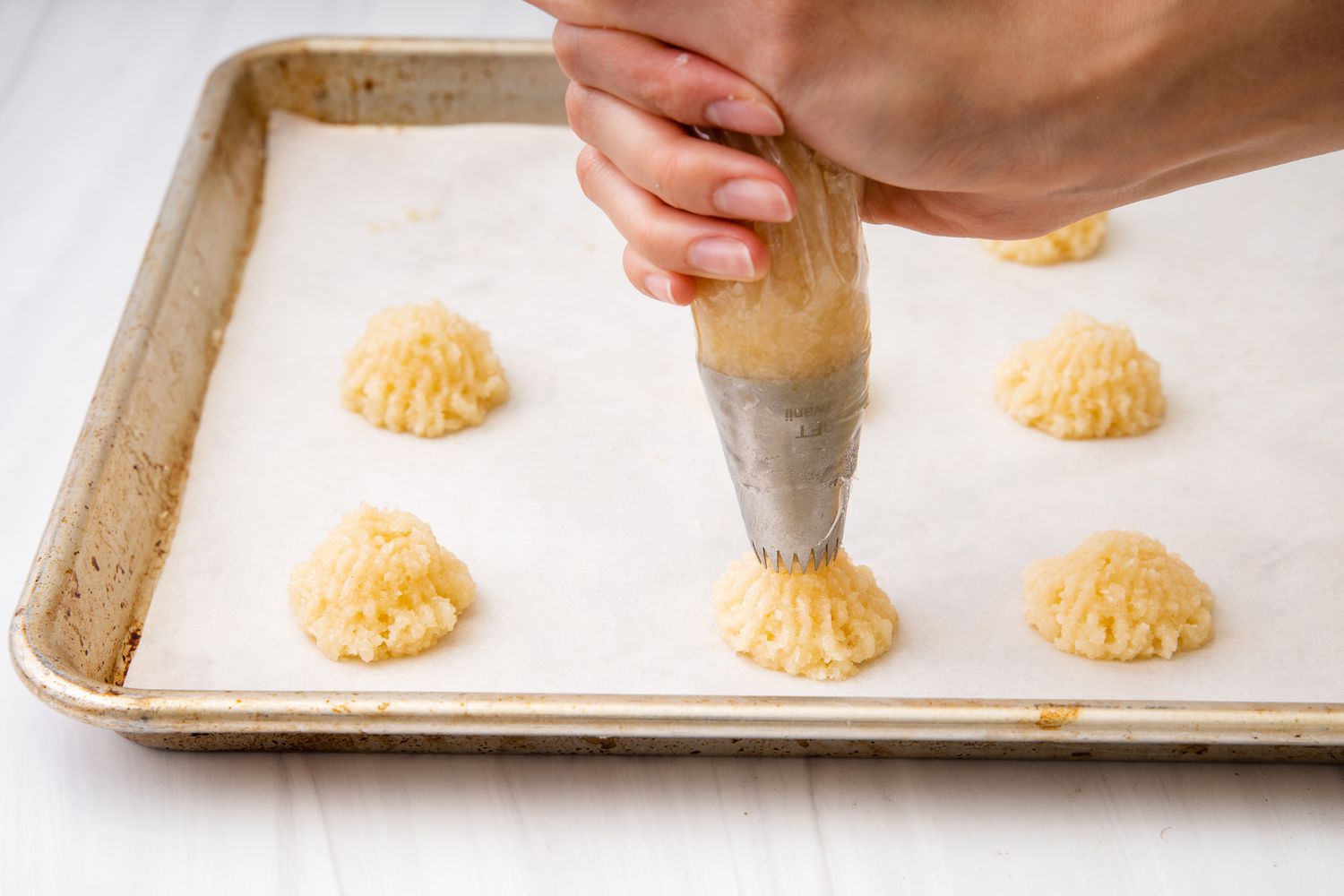 Coconut Macaroons being piped onto a baking sheet