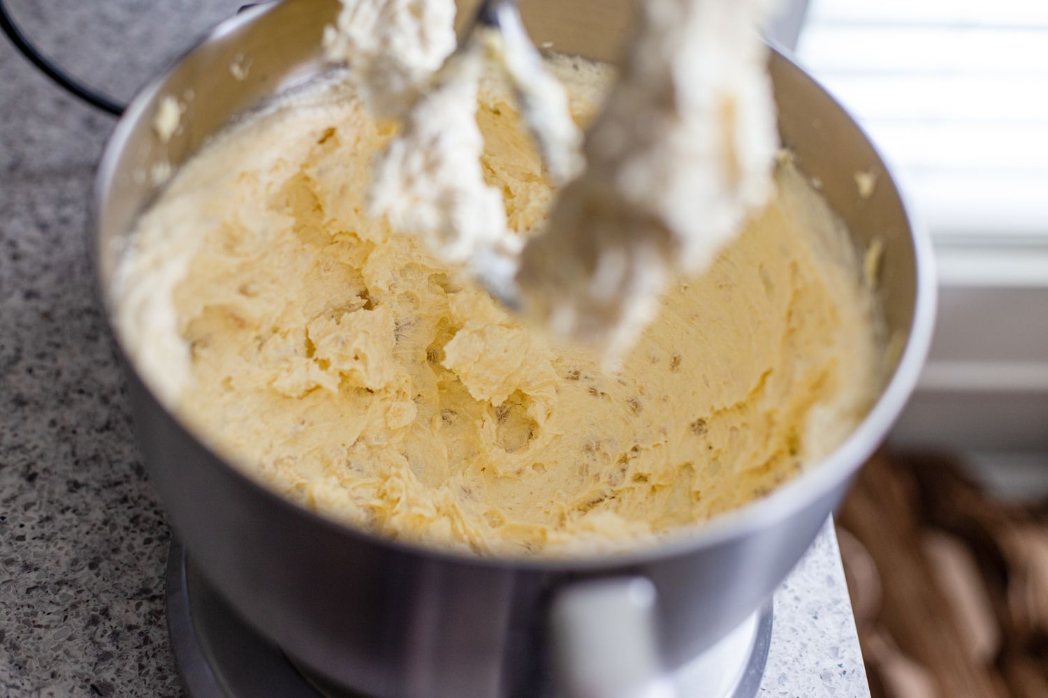 Bowl with creamed butter, sugar, and almond paste to make marzipan stamped cookies 