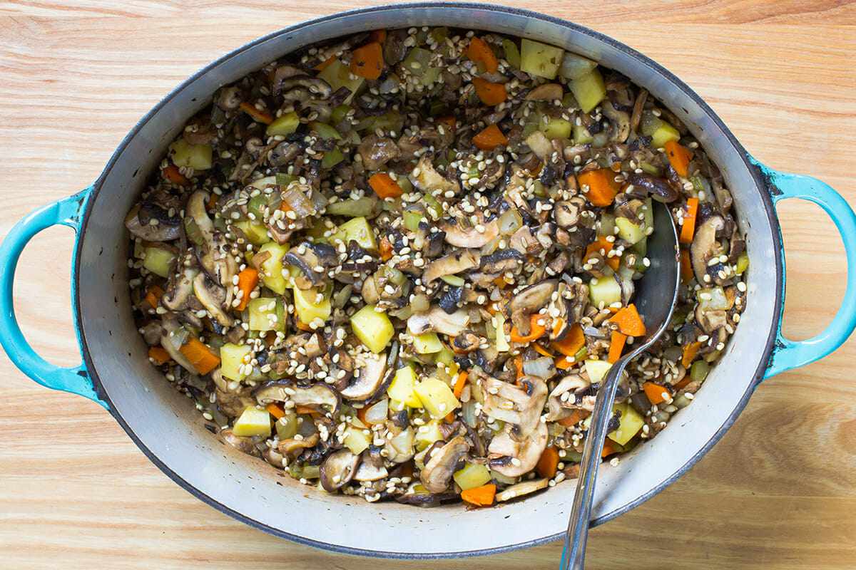 adding barley to a pot for a recipe for Mushroom Barley Soup
