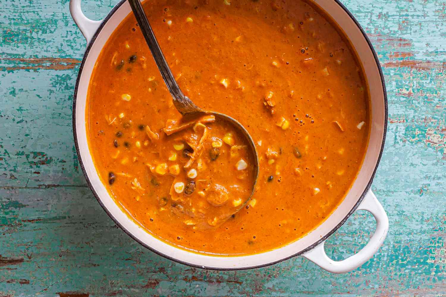 Dutch Oven of Creamy Chicken Enchilada Soup with a Ladle 