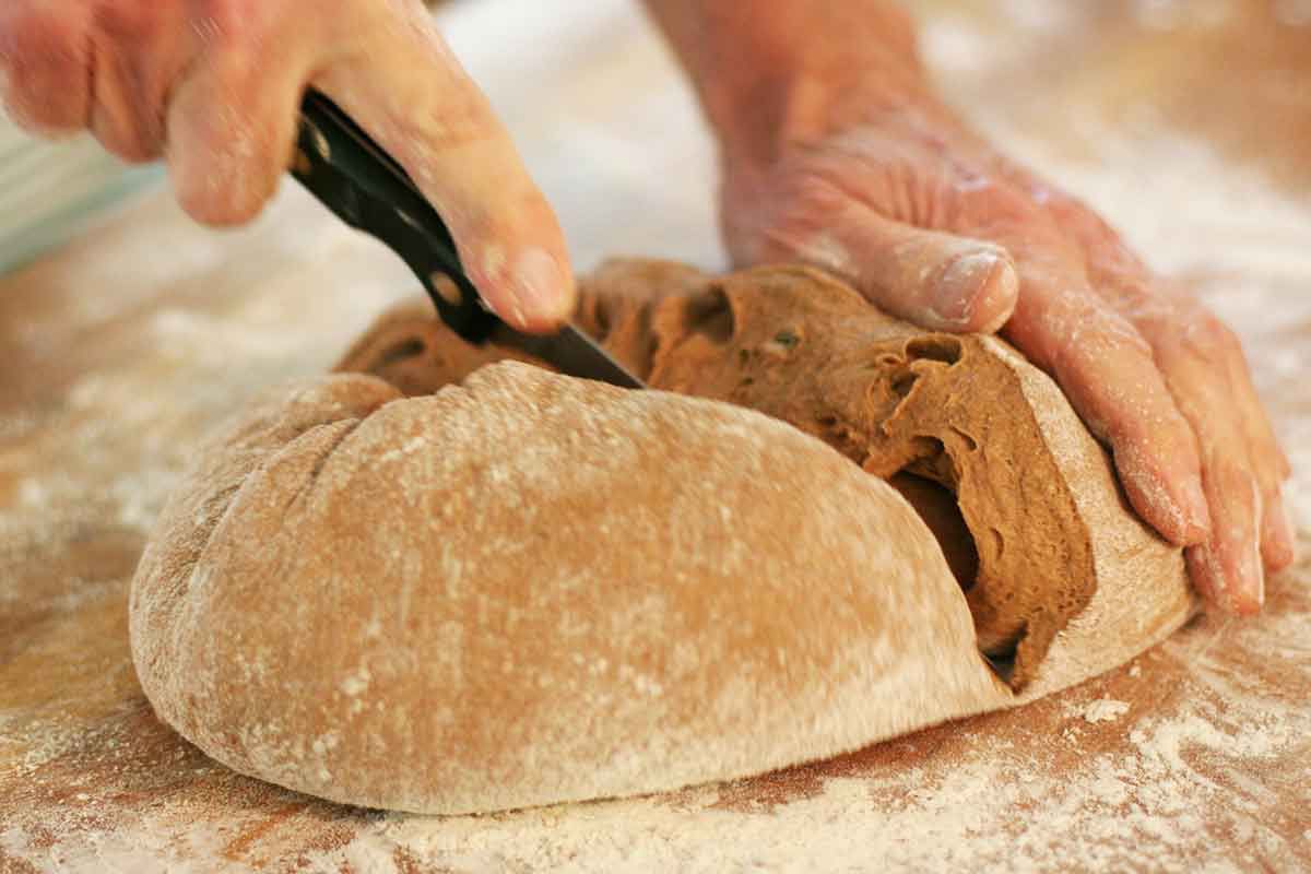 Cutting rye bread dough into two portions with a knife