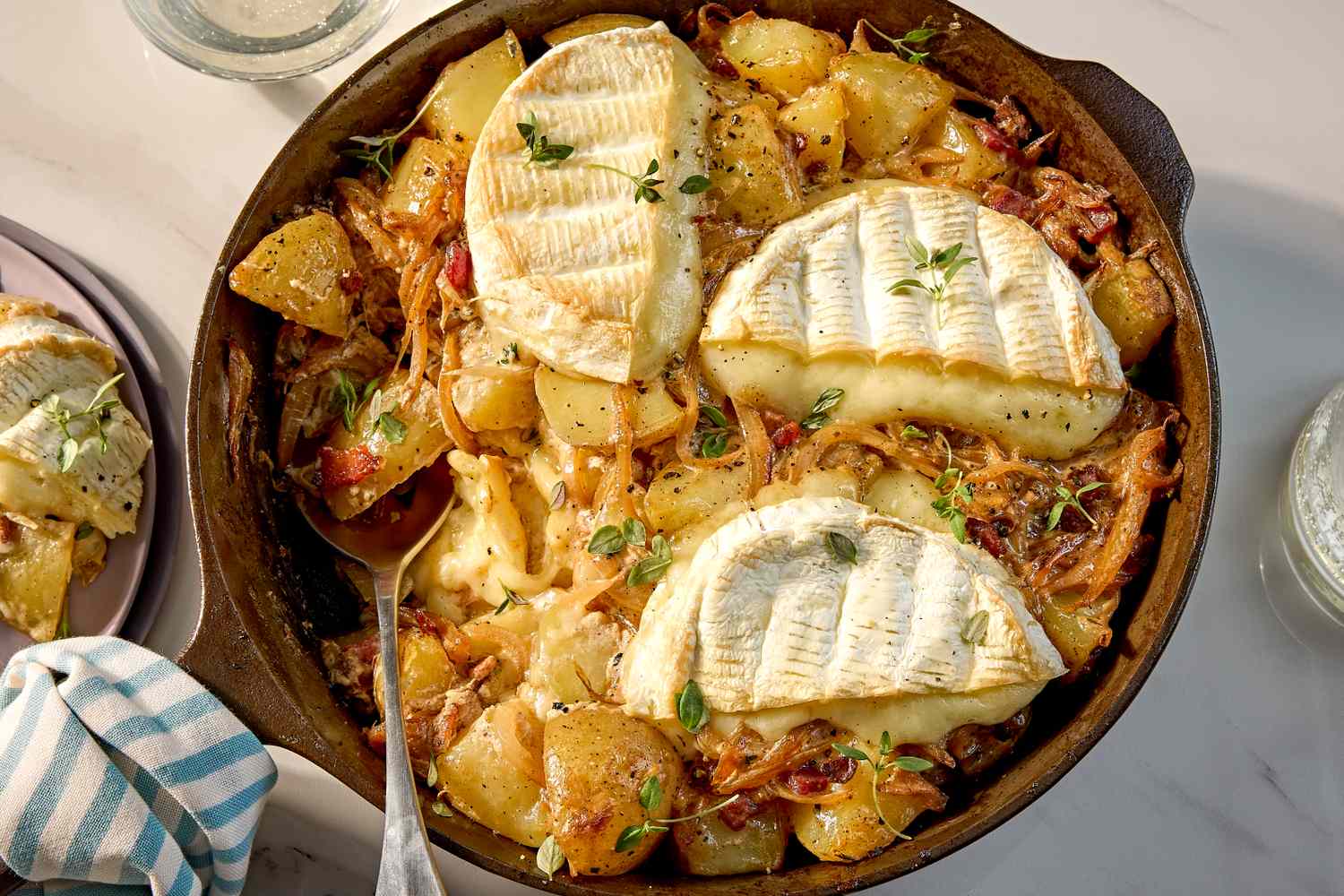 Skillet of tartiflette with melted cheese and potatoes served on a table