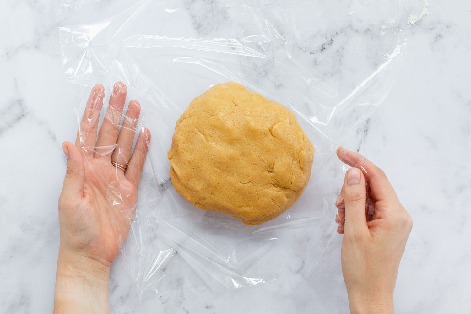 Dough for Peanut Butter Cookies being wrapped in plastic wrap.