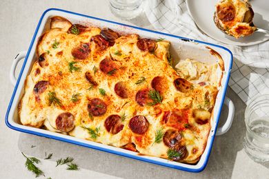 Rakott Krumpli (Hungarian Potato Casserole) in a 9x13 casserole dish, one serving on a plate