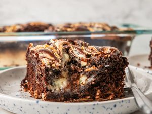 close-up of earthquake cake slice on a small plate and in the background, more cake in the pyrex dish
