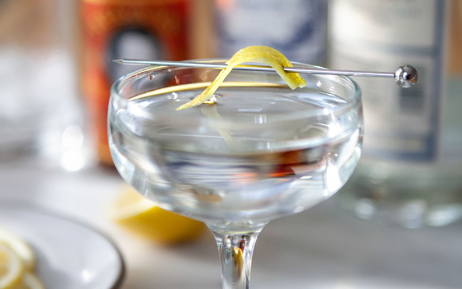 Close up of a Classic Gin Martini in a coupe glass garnished with lemon peel.