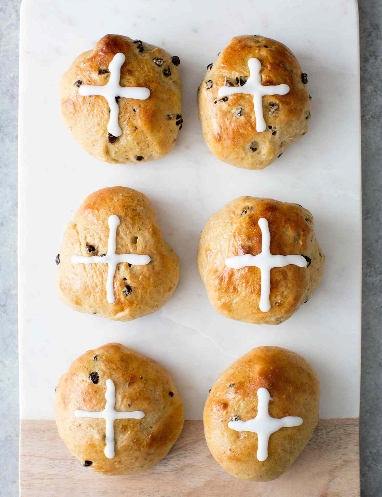 Easy Hot Cross Buns with sugar crosses on top on a board for serving
