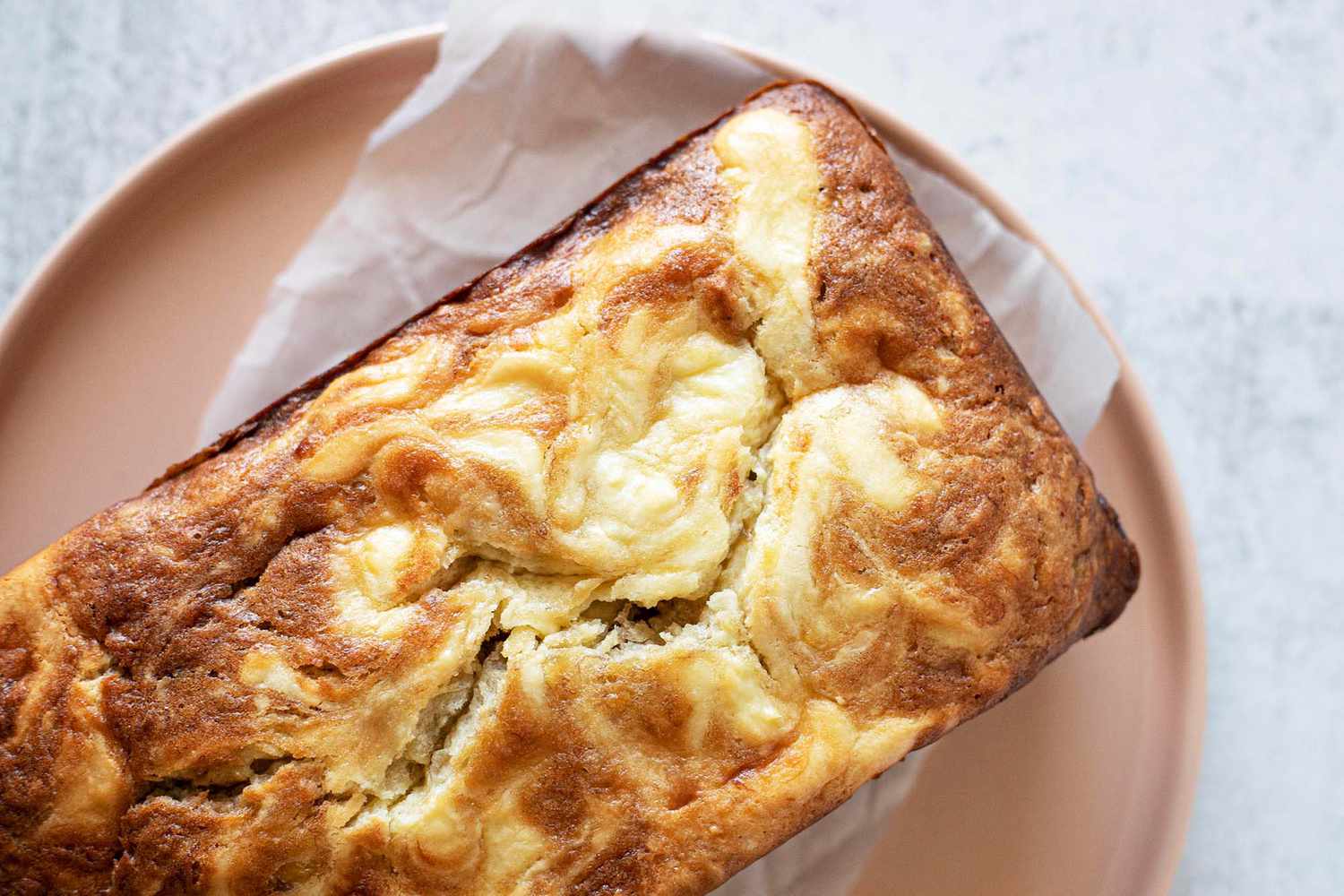 Banana bread loaf with cream cheese swirls on a plate