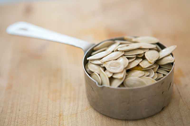 Pumpkin seeds in a measuring cup