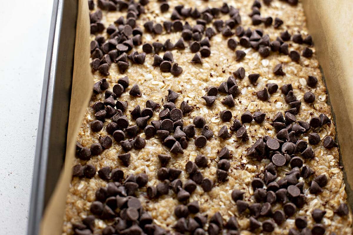 adding chocolate to caramelita cookie bars