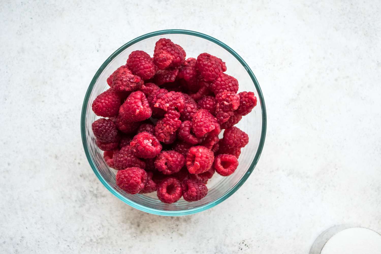 Overhead view of a bowl of raspberries to make fresh berry liqueur.