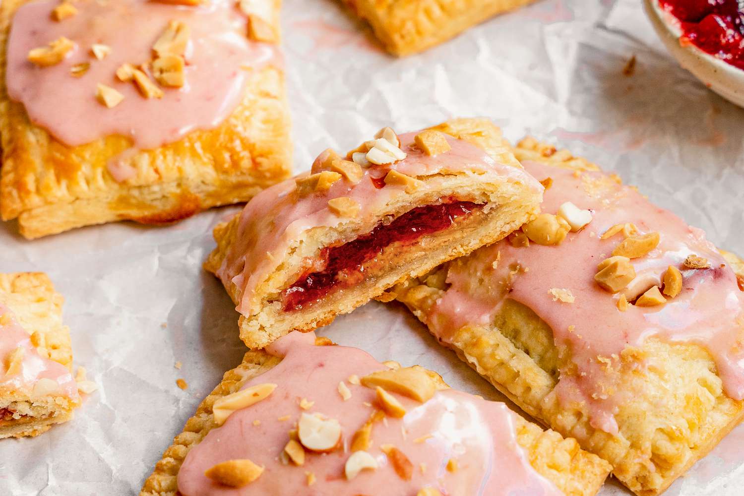 A Peanut Butter and Jelly Pop Tart Cut in Half, Leaning on More Gourmet Pop Tarts on a Piece of Parchment Paper