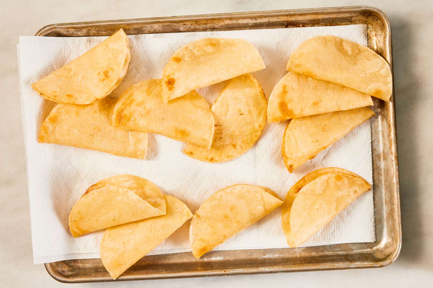 fried tortilla resting in a paper towel lined baking tray for crispy ground beef recipe