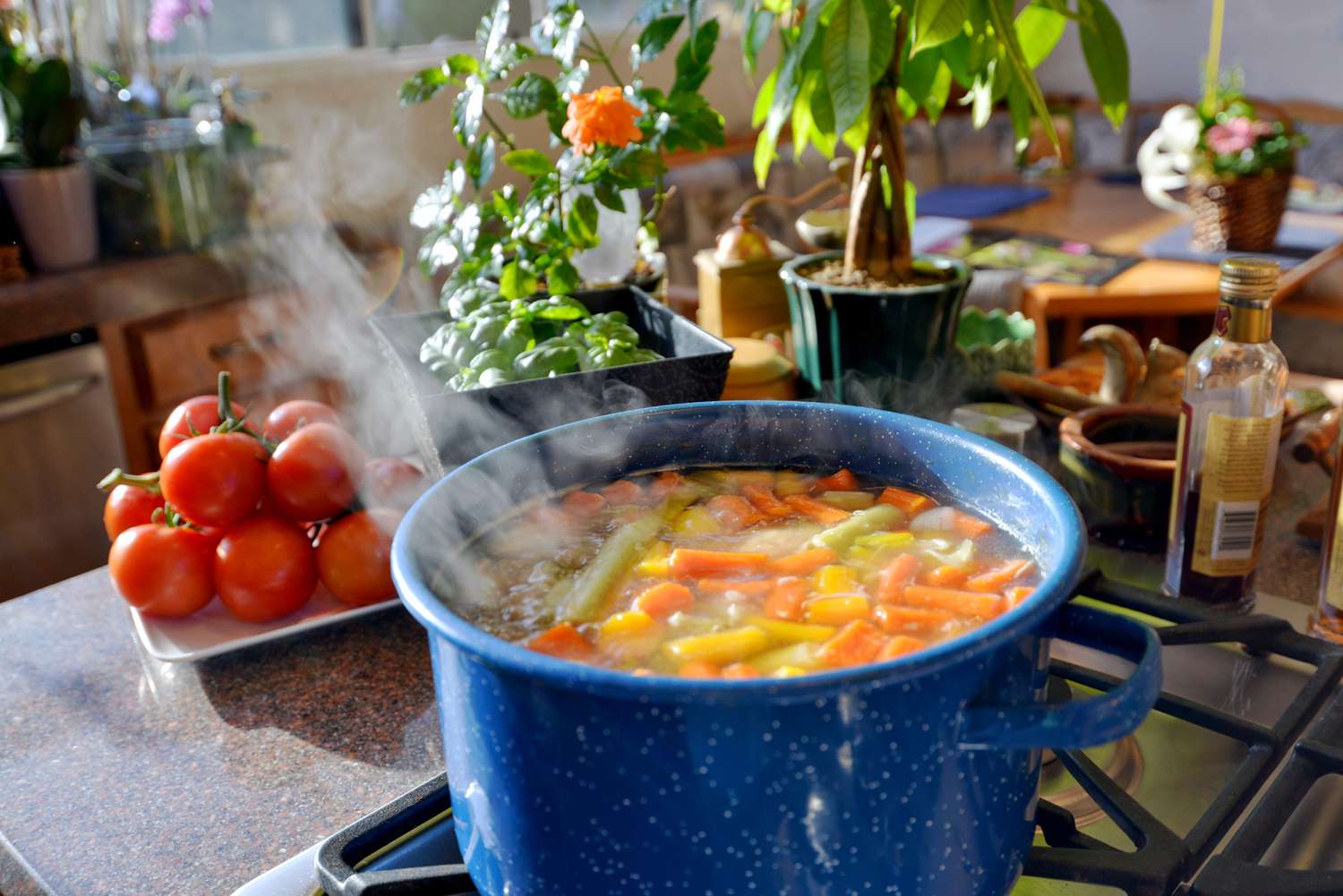 A big blue enamelware pot of soup simmering on the stovetop