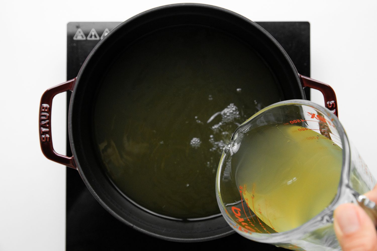 Chicken Broth Poured into a Dutch Oven on a Portable Burner for Congee Recipe