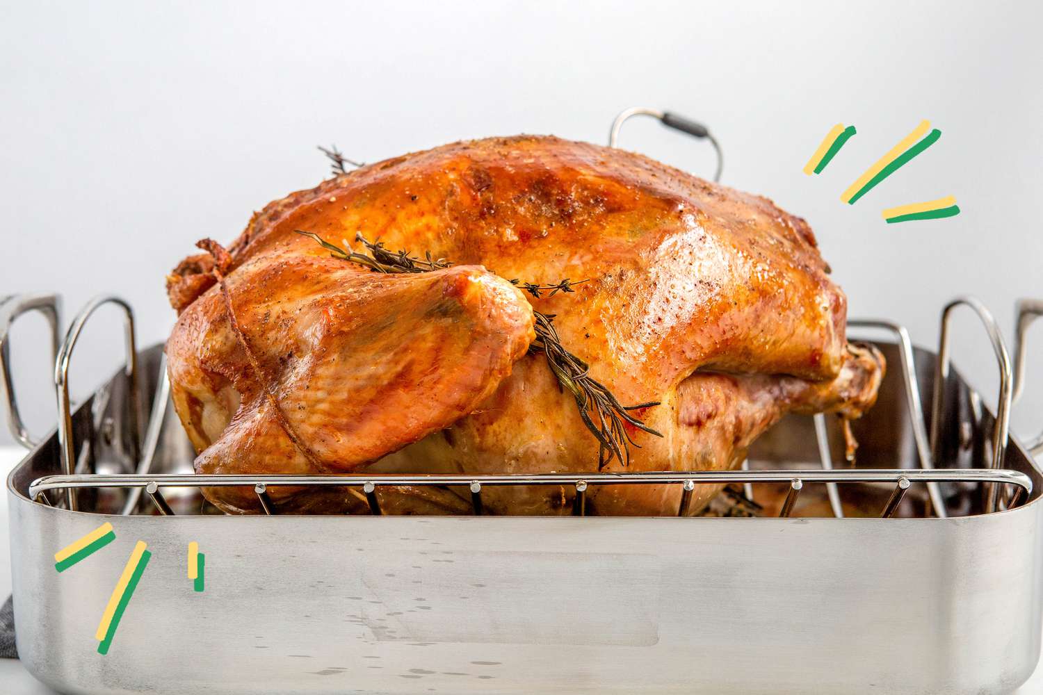 Photo of a baked turkey in a roasting pan with some blue and yellow lined illustrations next to it